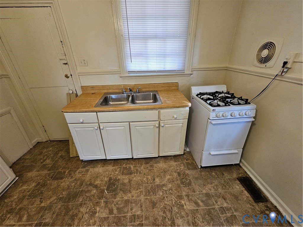 1803 Joplin Avenue Richmond, VA 23224 - Photo 5 of 9 Kitchen with white cabinetry, stove, light counter