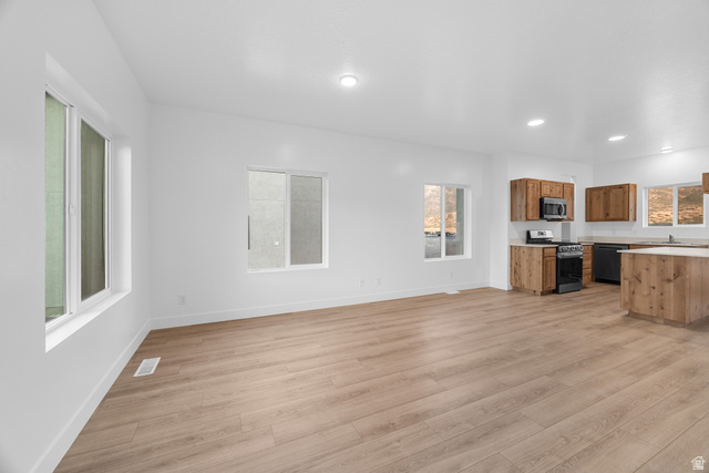 1563 South Deerbrook Road, Unit 267CHM Santaquin, UT 84655 - Photo 4 of 13 Open-concept living area featuring wood-finish flooring, white walls, recessed lighting, and multiple windows