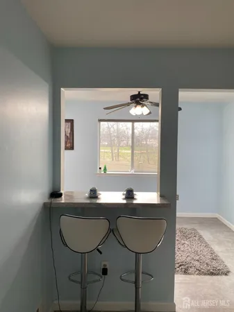 a room with a table chairs and a large mirror