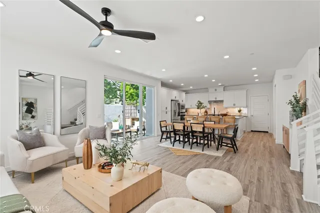 a living room with furniture kitchen view and a large window
