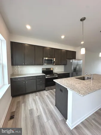 a kitchen with stainless steel appliances kitchen island a cabinets and wooden floor