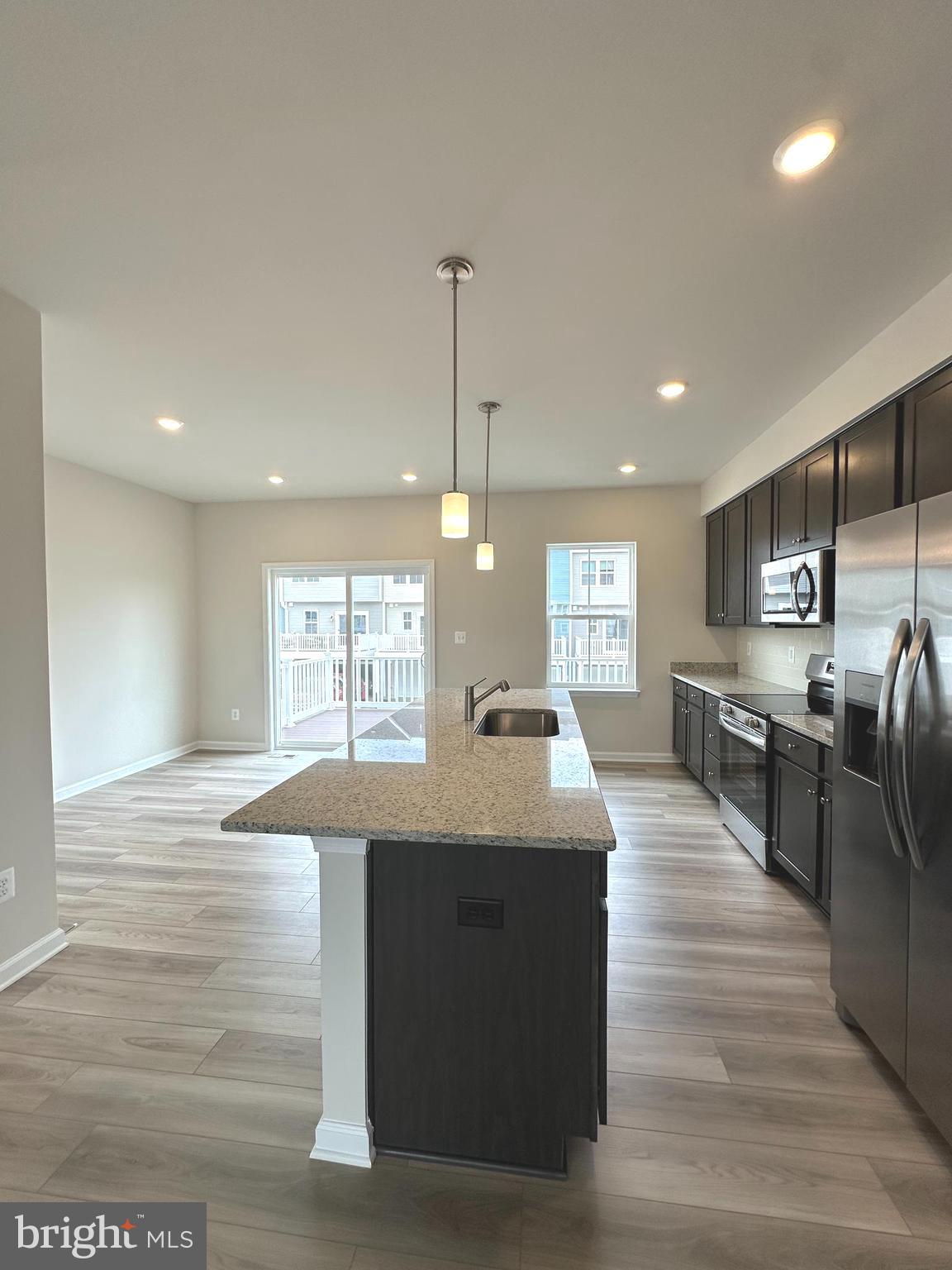 1258 Cedar Vly Road Ranson, WV 25438 - Photo 19 of 46 a large kitchen with stainless steel appliances kitchen island granite countertop a large counter top and stove top oven with wooden floor