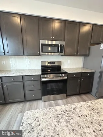 a kitchen with a stove a sink and a refrigerator