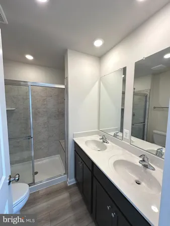 a bathroom with a double vanity sink mirror and shower