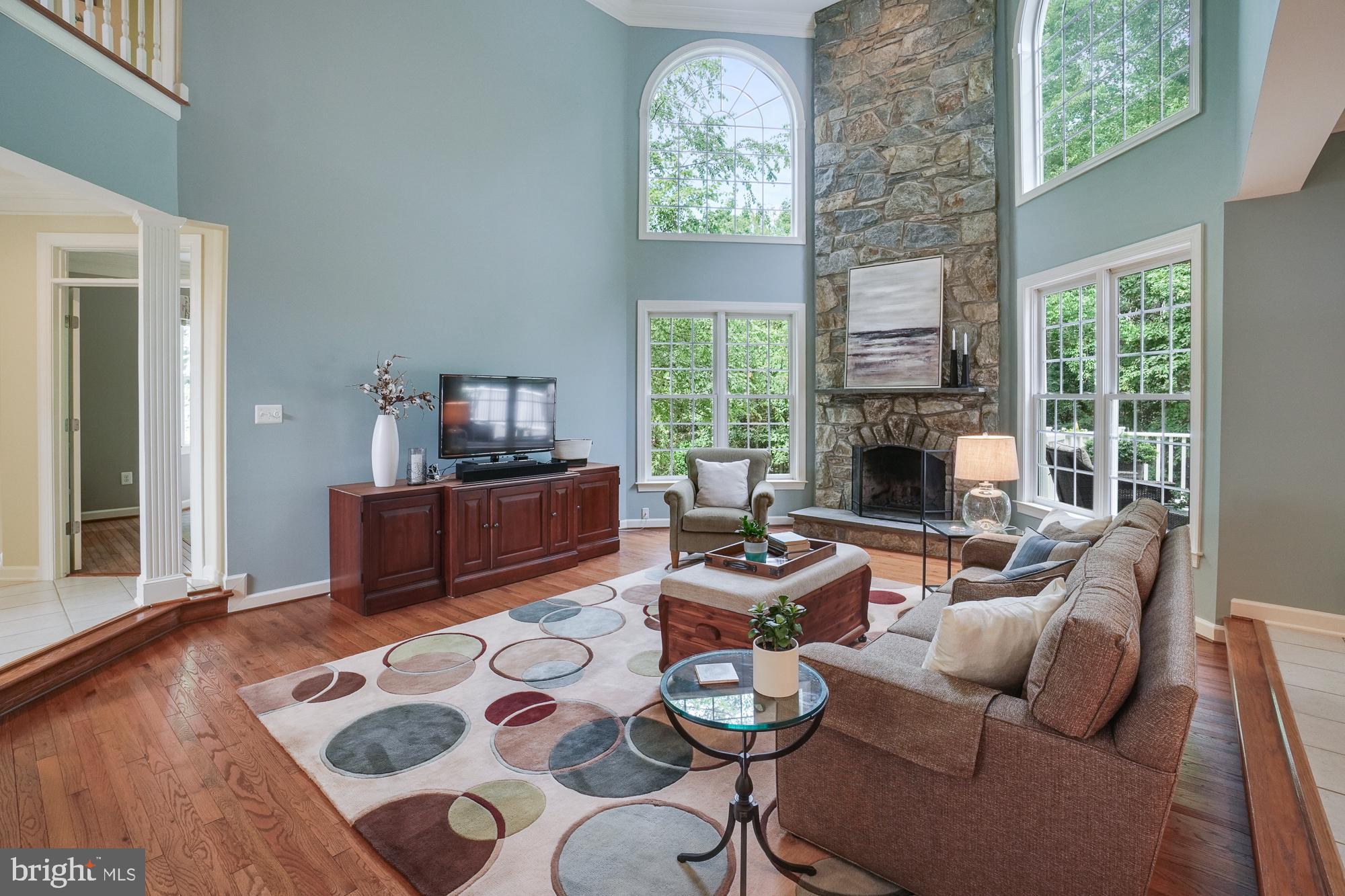 18 Hackett Court Poolesville, MD 20837 - Photo 22 of 82 Two-story stone fireplace and a wall of windows