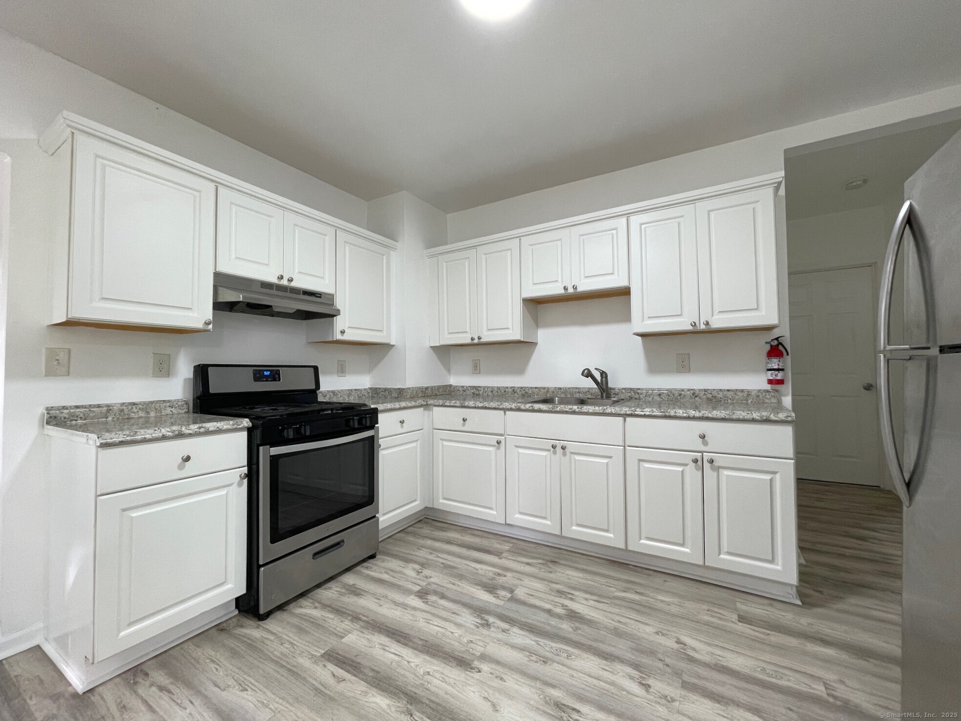 19 Townsend Street, Unit 1 New Haven, CT 06511 - Photo 2 of 8 a kitchen with granite countertop white cabinets and white appliances