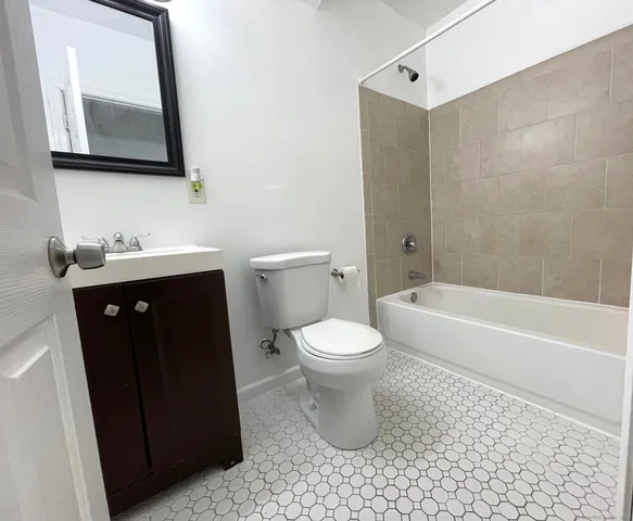a bathroom with a toilet a sink a mirror and bathtub