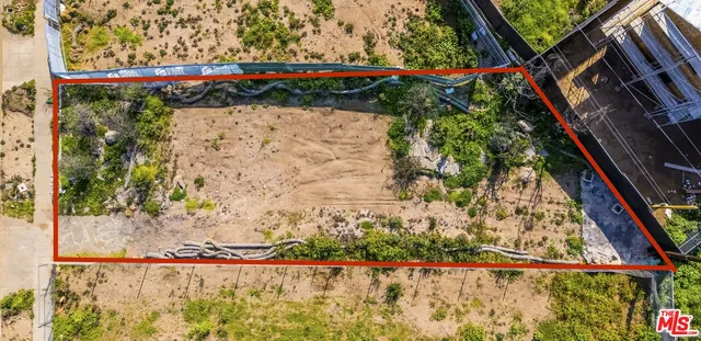 a view of a yard with wooden fence