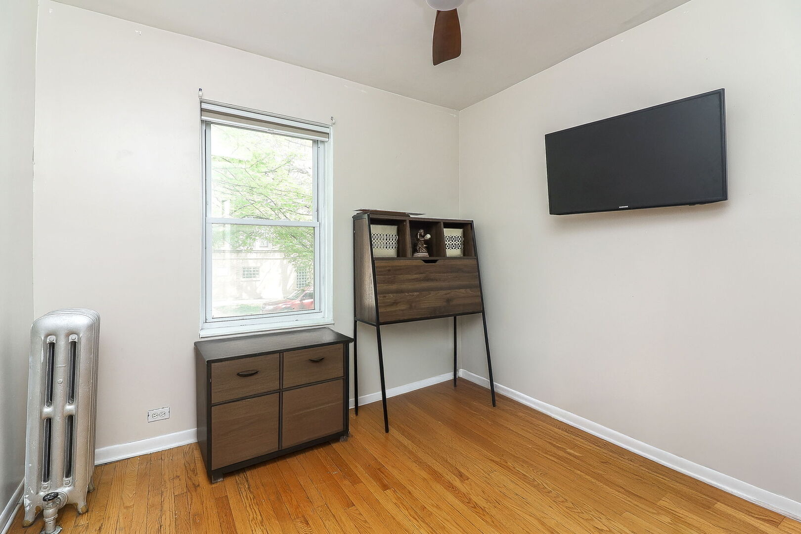 3707 West Cullom Avenue, Unit 1 Chicago, IL 60618 - Photo 11 of 16 a room with a flat screen tv potted plant and a wooden floor