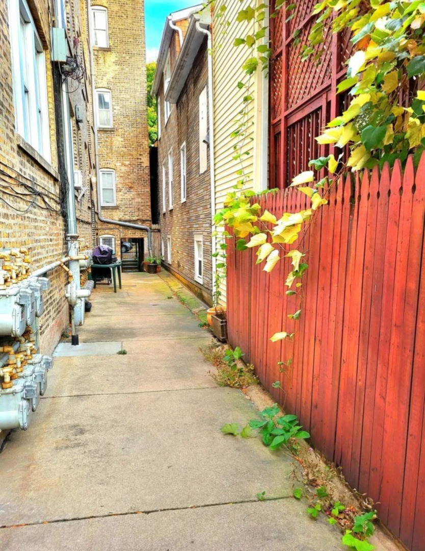 3707 West Cullom Avenue, Unit 1 Chicago, IL 60618 - Photo 14 of 16 a row of palm trees and building with wooden fence