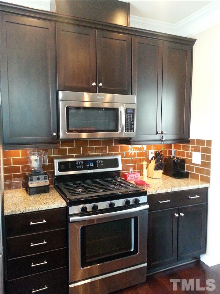 10131 Lynnberry Place Raleigh, NC 27617 - Photo 11 of 25 Whirlpool Gold Stainless Steel appliances including 5-Burner Gas Range w/Vented Exhaust, Wall-mounted Microwave & Dishwasher.