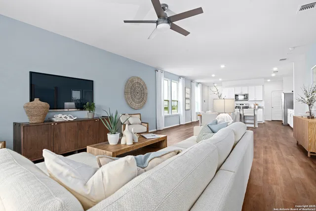 a living room with furniture and a wooden floor