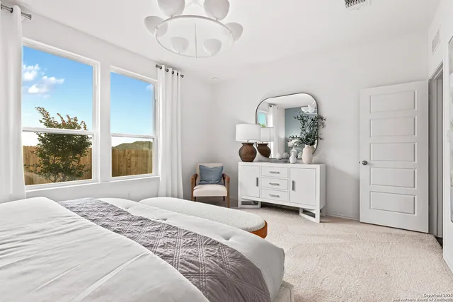 a bedroom with a bed and a large mirror on the dresser