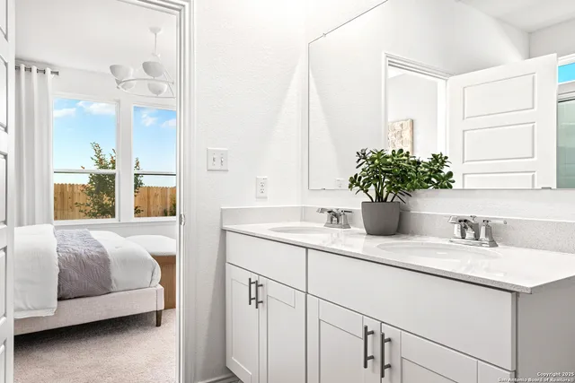 a en suite bathroom with a double vanity sink and mirror