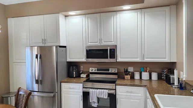 a kitchen with stainless steel appliances granite countertop a refrigerator and a stove top oven