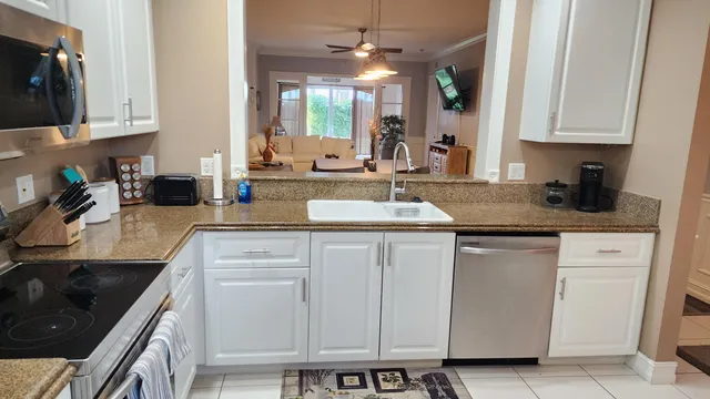 a kitchen with granite countertop white cabinets and white appliances