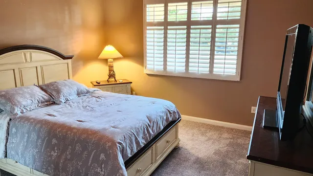 a bedroom with a bed and a window