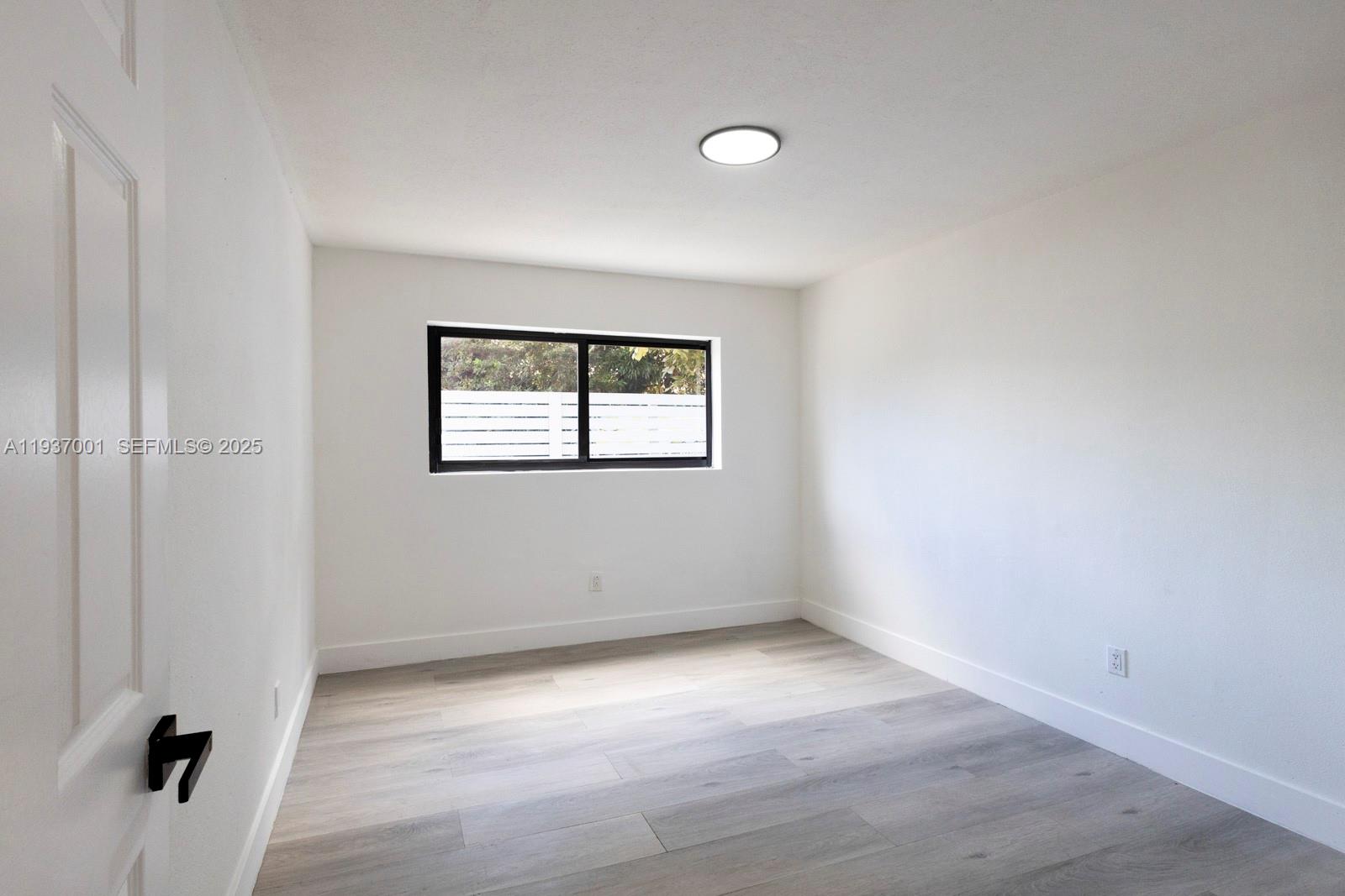 37 Northwest 59th Street, Unit 7 Miami, FL 33127 - Photo 12 of 15 an empty room with a window