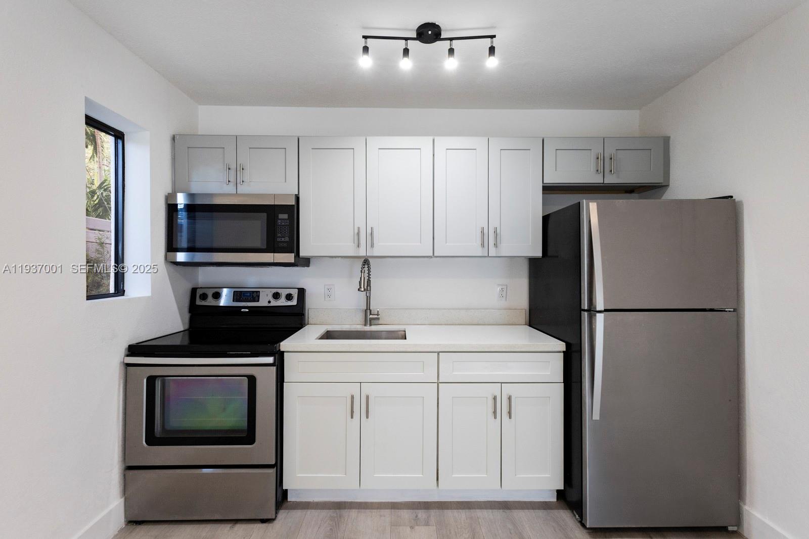 37 Northwest 59th Street, Unit 7 Miami, FL 33127 - Photo 7 of 15 a kitchen with a refrigerator stove and microwave