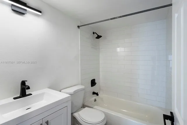 a bathroom with a bathtub shower sink vanity and toilet