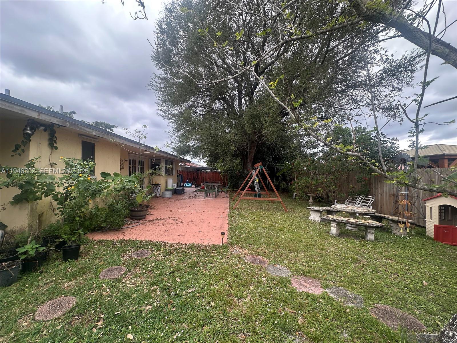 5965 Northwest 200th Street Hialeah, FL 33015 - Photo 20 of 23 a view of backyard of house with outdoor seating and green space