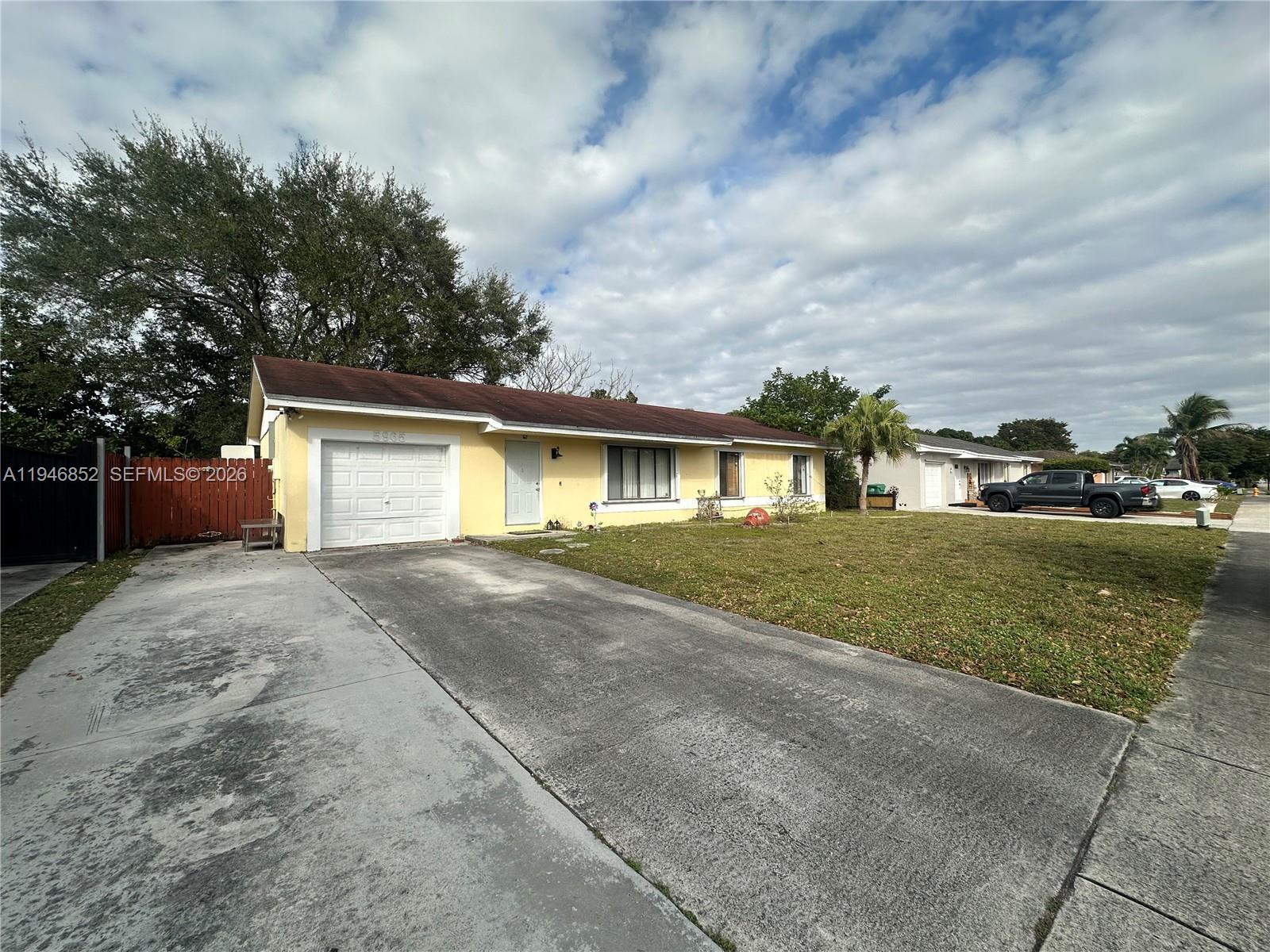 5965 Northwest 200th Street Hialeah, FL 33015 - Photo 2 of 23 a front view of a house with a yard and garage