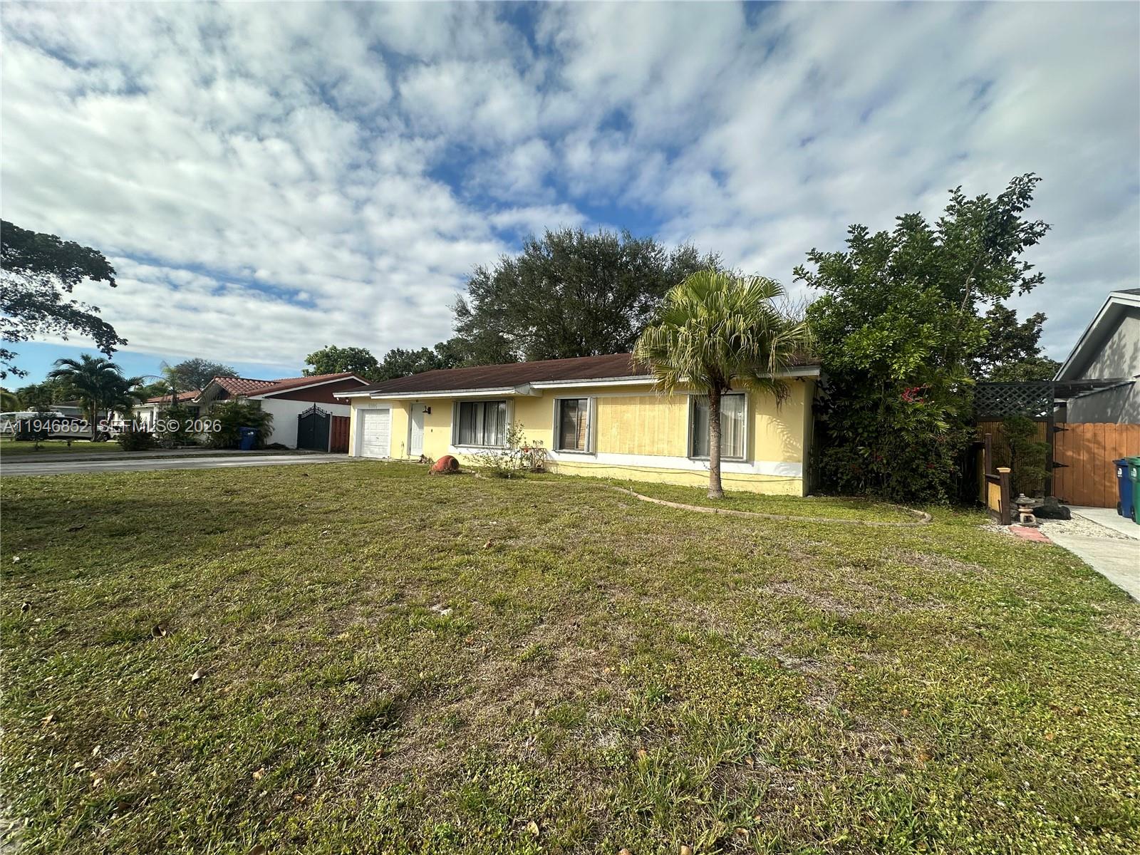 5965 Northwest 200th Street Hialeah, FL 33015 - Photo 3 of 23 a front view of a house with a garden