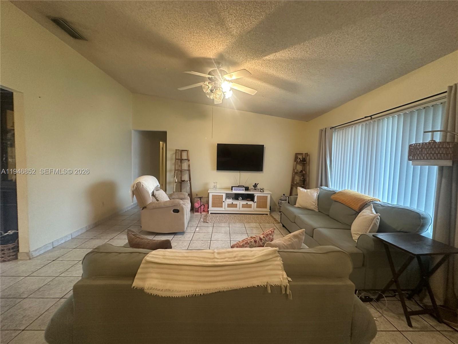 5965 Northwest 200th Street Hialeah, FL 33015 - Photo 5 of 23 a living room with furniture and a flat screen tv