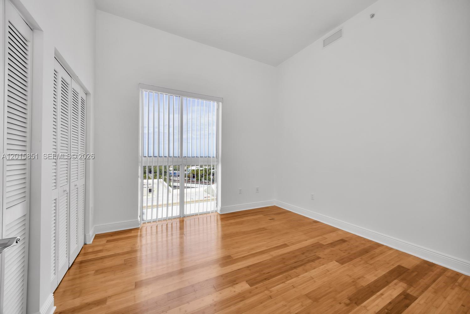 7275 Southwest 90th Street, Unit C719 Miami, FL 33156 - Photo 18 of 25 a view of an empty room with wooden floor and a window