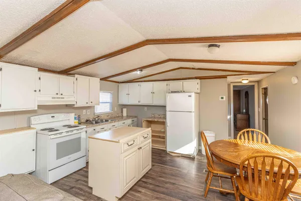 a kitchen with a stove a refrigerator and furniture