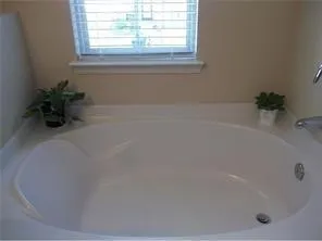 a white bath tub sitting in a bathroom next to a window