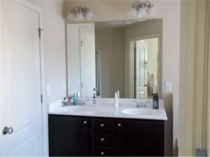 a bathroom with double sink and two mirror