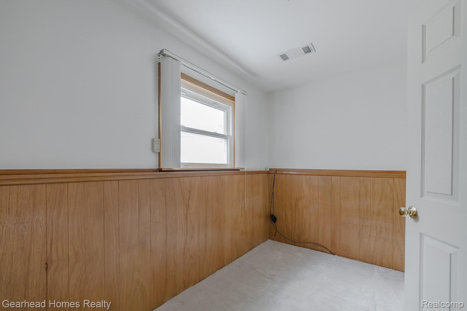 3356 Harding Street Dearborn, MI 48124 - Photo 35 of 48 Wood-paneled wainscoting with a decorative trim, white painted walls, and light-colored carpeting