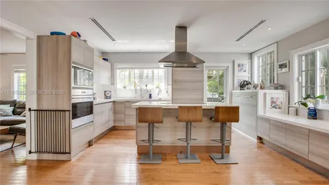 a kitchen with stainless steel appliances kitchen island granite countertop a table chairs and a refrigerator
