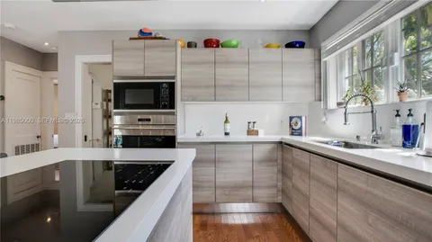 a kitchen with stainless steel appliances kitchen island granite countertop a sink and a stove