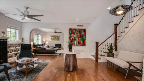 a living room with furniture and a wooden floor