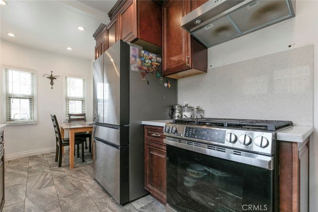 a kitchen with stainless steel appliances granite countertop a stove a sink and a refrigerator