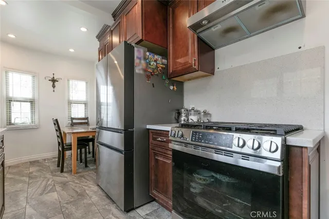 a kitchen with stainless steel appliances granite countertop a stove a sink and a refrigerator