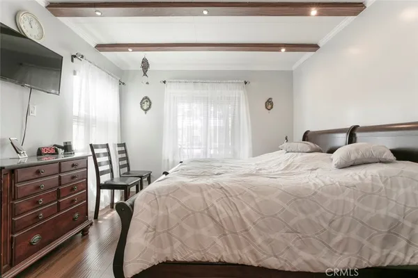 a large bedroom with a bed and a flat tv screen