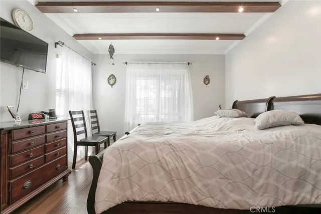 a large bedroom with a bed and a flat tv screen