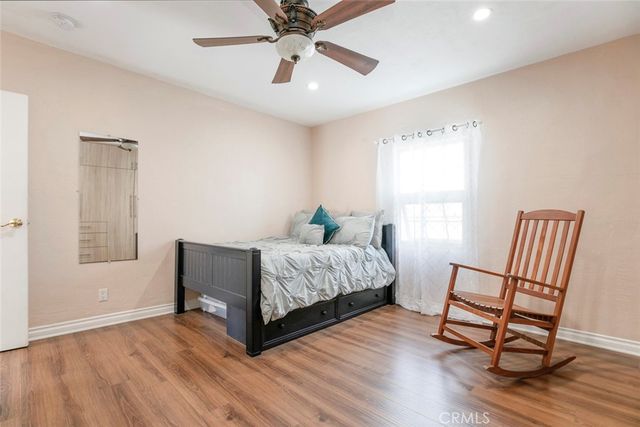 a bedroom with a bed furniture and a ceiling fan