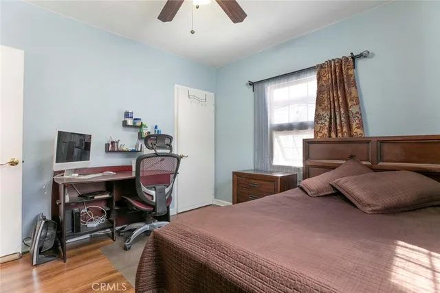a bedroom with a bed a chandelier and a chair