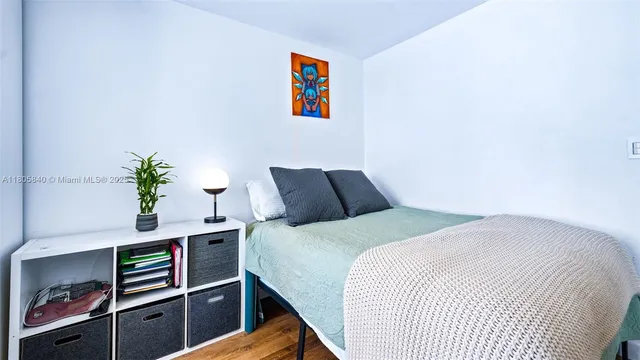 a bedroom with a bed and a potted plant