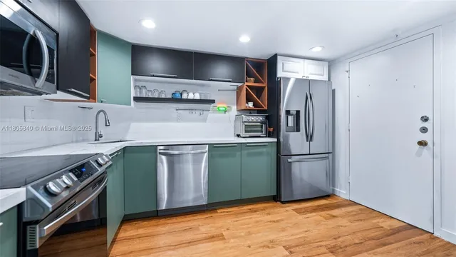 a kitchen with kitchen island a sink stainless steel appliances and cabinets