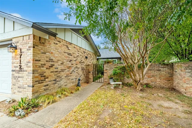 a backyard of a house with a large tree