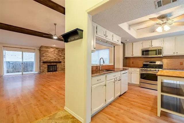 a kitchen with stainless steel appliances a refrigerator sink and microwave