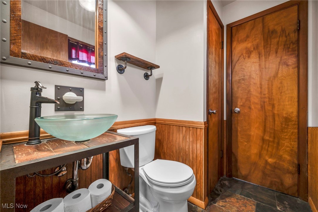 36462 Chestnut Ridge Road North Ridgeville, OH 44039 - Photo 28 of 47 Half bath with a wainscoted wall, wood walls, stone tile floors, and vanity