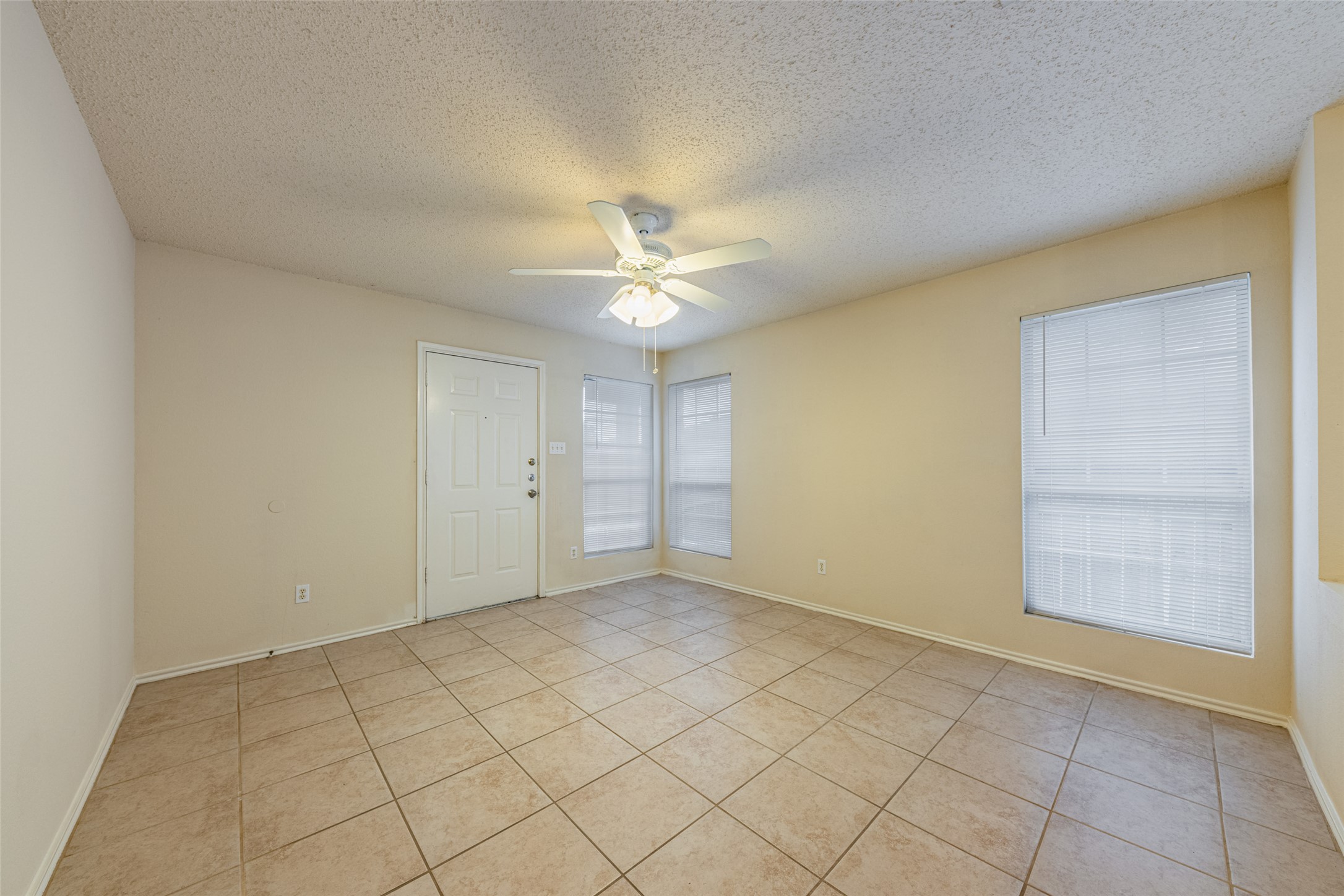7216 Aldea Drive, Unit A Austin, TX 78745 - Photo 4 of 25 Spacious room featuring neutral-toned walls, tile flooring, and multiple windows