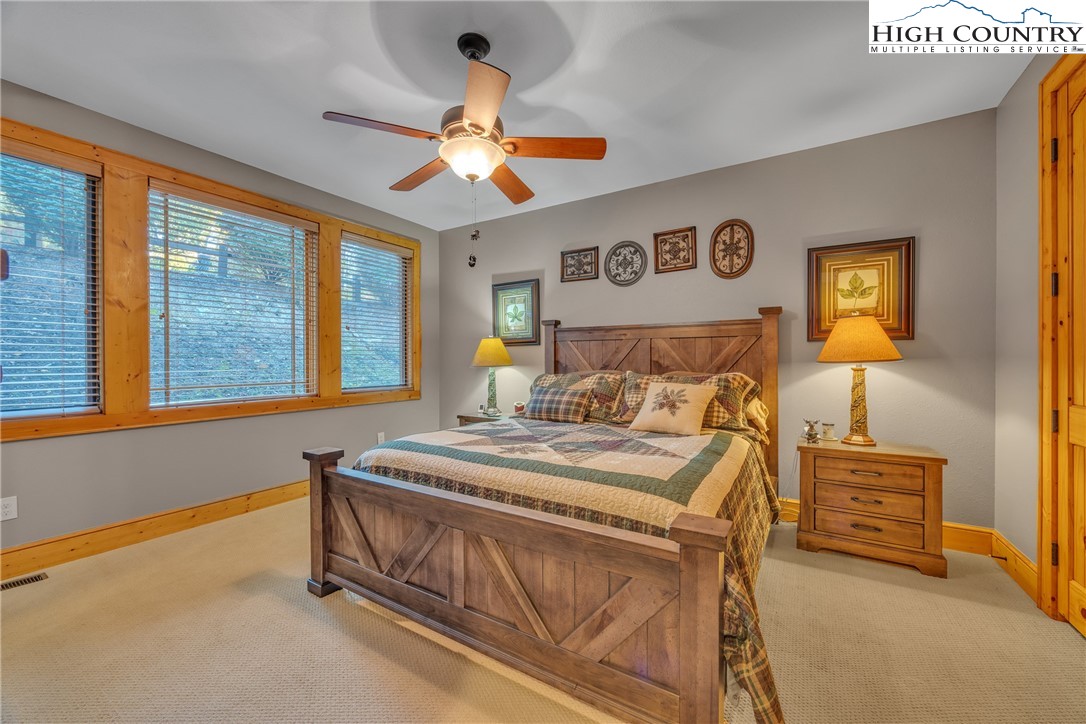 89 Springhouse Drive, Unit A4 Elk Park, NC 28622 - Photo 23 of 46 a bedroom with a bed a ceiling fan and a large window