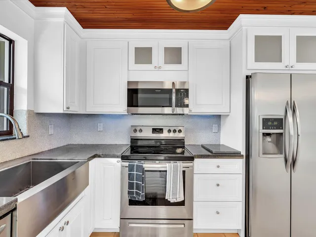a kitchen with stainless steel appliances a stove a microwave and a sink